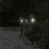 A pathway lined with garden lights in a dark garden setting. Voir les images du produit