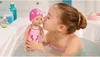 A young girl is giving a bath to a baby doll in a bathtub. Produktbild-Vorschau