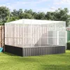 A large silver aviary is set up in a grassy backyard with trees and a fence in the background. Náhled obrázku produktu