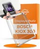 A hand holding a bicycle computer display with a protective cover in front of a product box. Produktbild-Vorschau