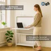 A woman is using a wall-mounted desk with a laptop. Produktbild-Vorschau