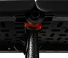 A close-up view of the underside of a camping table, showing the connection point of a leg and a red plastic locking mechanism. Podgląd zdjęcia produktu