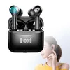 A pair of black wireless earbuds in a charging case, with a woman in the background. Produktbild-Vorschau