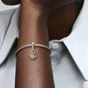 A close-up shot of a person's arm wearing a Pandora bracelet with a sun and moon charm. Produktbild-Vorschau
