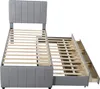 A gray upholstered bed frame with a pull-out trundle bed and drawers, shown from a slightly elevated side angle against a white background. Produktbild-Vorschau