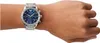 A man's wrist wearing a silver Emporio Armani watch with a blue dial. Náhľad obrázku produktu