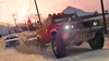 A red off-road vehicle is being chased by two police cars on a dusty road in a desert landscape. Produktbild-Vorschau