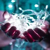 Hands holding a string of white LED lights. Anteprima dell’immagine prodotto