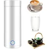 A white electric kettle is shown next to a cup of coffee, a glass of milk, and a tea set. Produktbild-Vorschau