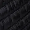 A close-up view of the quilted texture of a black jacket. Produktbild-Vorschau