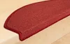 A close-up view of a red stair mat on a wooden staircase. Produktbild-Vorschau
