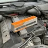 A product box for a torque wrench is placed on top of a car engine. Voir les images du produit