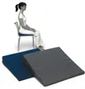 A woman is sitting on a chair, demonstrating proper posture. Two wedge cushions are in the foreground. Produktbild-Vorschau