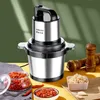 A Sokany electric chopper is displayed on a table with ingredients like chili peppers and garlic, suggesting its use in food preparation. Voir les images du produit