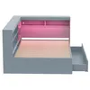 A grey bed frame with built-in shelving and a drawer, illuminated by pink LED lights. Produktbild-Vorschau