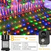 A net of colorful lights draped over a wooden fence and grass. Produktbild-Vorschau
