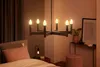 A bedroom scene with a chandelier and bedside lamp. Produktbild-Vorschau
