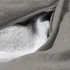 A close-up view of a grey bean bag with a zipper partially open, revealing the white mesh inner lining and EPS bead filling. Produktbild-Vorschau