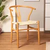 A natural wood chair with a woven seat is shown in a room setting. Podgląd zdjęcia produktu