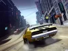 A yellow car with black racing stripes is driving down a city street, with buildings on either side. Produktbild-Vorschau