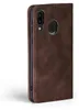 A close-up side view of a brown leather flip case for a smartphone, showing the camera cutout and fingerprint sensor. Produktbild-Vorschau