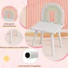 A children's chair with a rainbow design on the backrest, shown in a room with pink, ribbed walls and a wooden floor. The image includes callouts highlighting features like the curved backrest, solid pine legs, and anti-slip felt glides. Voir les images du produit