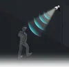 A person walks towards a security camera mounted on a wall, which emits detection waves. Náhľad obrázku produktu