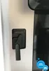 A close-up of a black lever on the side of a silver appliance. Produktbild-Vorschau