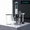A hand blender set is displayed on a countertop with a textured dark background. Produktbild-Vorschau