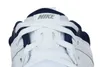 A close-up view of the top of a white Nike shoe with navy blue accents. Voir les images du produit