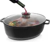 A raw turkey is being placed in a black oval roasting pan with a glass lid, and red wine is being poured into the pan through a small opening in the lid. Náhled obrázku produktu