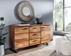 A modern living room with a wooden sideboard, a large round mirror, and a window with a view of trees. Produktbild-Vorschau
