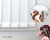 Close-up of white vertical blinds with a circular inset showing hands adjusting the bead chain. Voir les images du produit