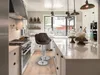 A modern kitchen with bar stools at an island. Podgląd zdjęcia produktu