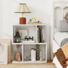 A white bookshelf with various decorative items and books placed on its shelves, next to a bed. Produktbild-Vorschau