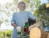 A person is using a cordless chainsaw to cut a log in an outdoor setting. Produktbild-Vorschau