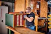 A man is working on a chair in a workshop. Anteprima dell’immagine prodotto