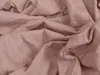 A close-up view of crumpled apricot-colored fabric, likely a bedsheet. Produktbild-Vorschau