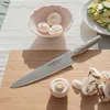 A Global G-2 Fleischmesser is placed on a wooden cutting board next to mushrooms and a bowl of mushrooms. Sliced zucchini is visible in the background. Anteprima dell’immagine prodotto