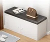 A white shoe cabinet with a dark upholstered bench top, a handbag, and books on top. Anteprima dell’immagine prodotto