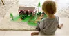 A young child is playing with a toy farm set on the floor. Produktbild-Vorschau