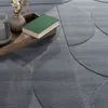 A close-up of a rug with a book and vase on a wooden tray. Anteprima dell’immagine prodotto