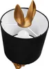 A close-up view of a table lamp with a black fabric shade and a gold-colored base shaped like a rabbit's ears and paws. Produktbild-Vorschau