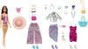 A Barbie doll with various outfits and accessories laid out around her. Voir les images du produit