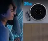 A woman sleeping peacefully in bed next to an air purifier. Produktbild-Vorschau