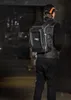 A person wearing a tool backpack in a warehouse-like setting. Náhľad obrázku produktu