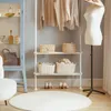 A clothing rack with clothes and accessories, including baskets and shoes, in a room setting. Produktbild-Vorschau