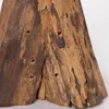 A close-up view of the textured surface of a wooden object, likely a stool or decorative piece, showing natural grain and small holes. Náhľad obrázku produktu