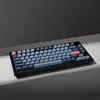A black keyboard with gray and red keys is placed on a light gray surface against a dark gray background. Produktbild-Vorschau
