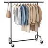 A black metal garment rack with various clothing items and a handbag hanging on it. Produktbild-Vorschau
